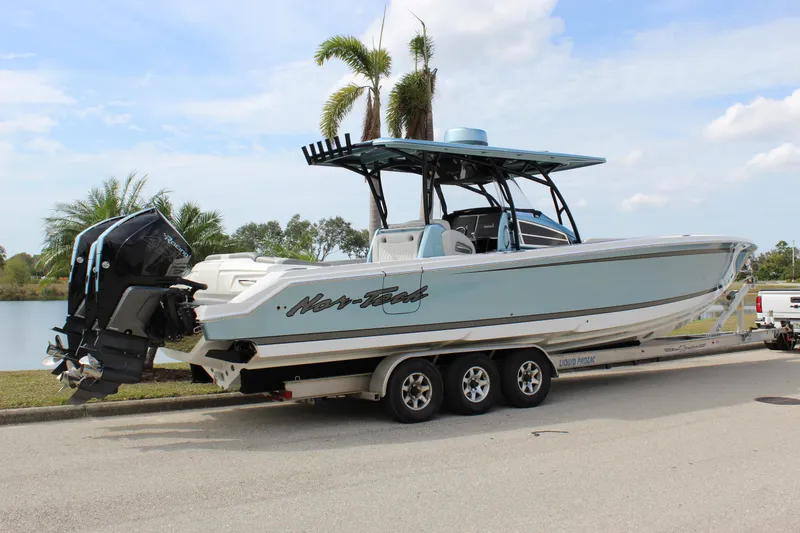 Slide: The Image of 2021 Nor-Tech 390 Sport Center Console boat on trailer, parked near a lake. - 17