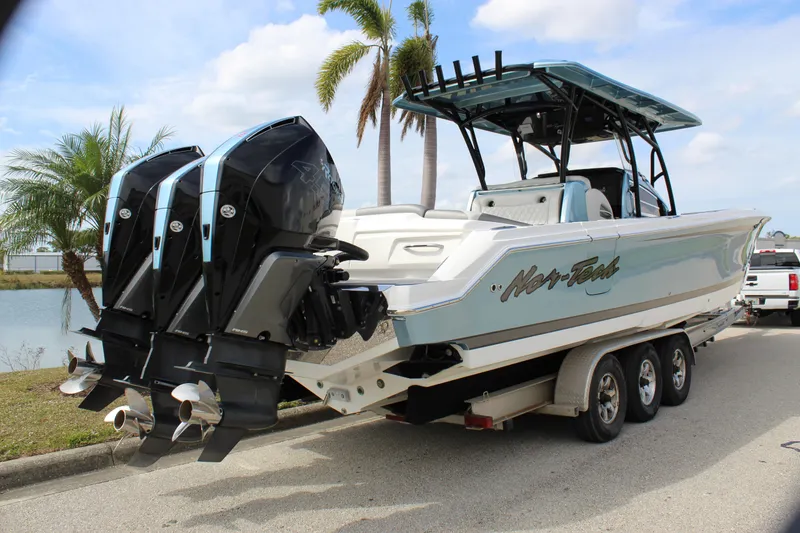 Slide: The Image of 2021 Nor-Tech 390 Sport Center Console boat with triple engines on a trailer. - 21