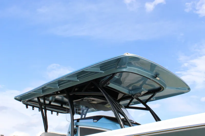 Slide: The Image of 2021 Nor-Tech 390 Sport Center Console boat with sleek blue canopy against a clear sky. - 28