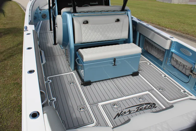 Slide: The Image of 2021 Nor-Tech 390 Sport Center Console boat interior with blue and white seating and deck. - 34