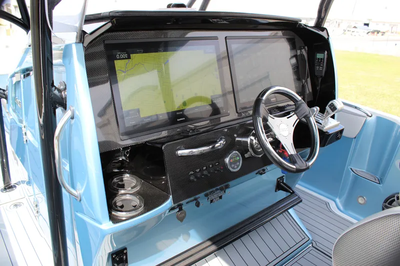 Slide: The Image of 2021 Nor-Tech 390 Sport Center Console dashboard with dual screens and steering wheel. - 49