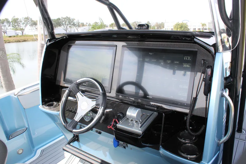 Slide: The Image of 2021 Nor-Tech 390 Sport Center Console helm with dual screens and steering wheel. - 51