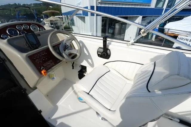 Slide: The Image of 1999 Bayliner 2655 Ciera Sunbridge cockpit with steering wheel and white seating. - 14
