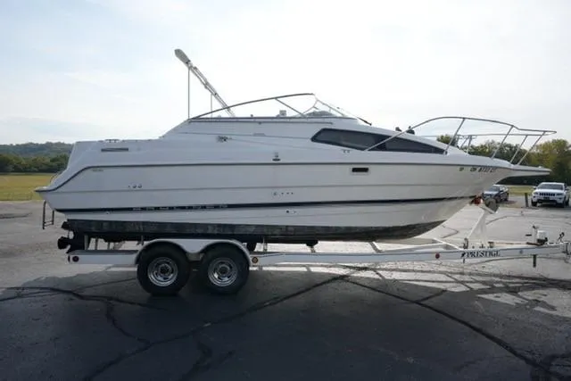 Slide: The Image of 1999 Bayliner 2655 Ciera Sunbridge boat on trailer, parked outdoors. - 8
