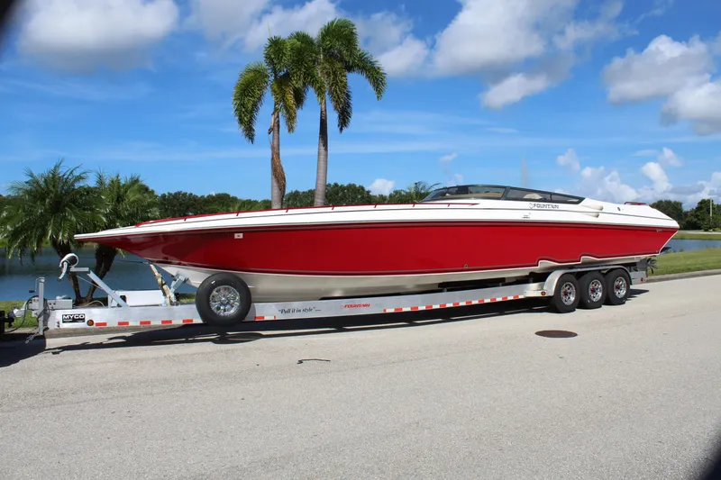 Slide: The Image of 2007 Fountain 42 Lightning speedboat on trailer, parked near palm trees and water. - 1