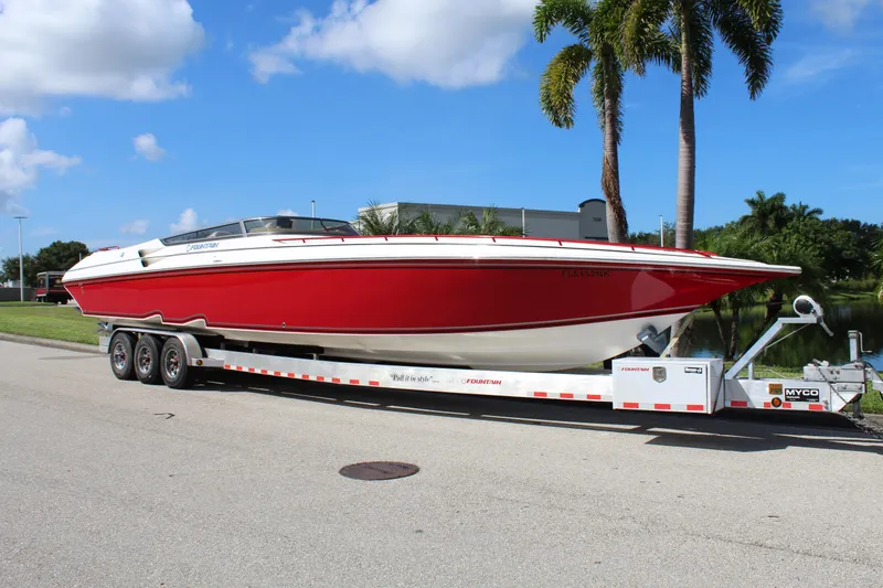 Slide: The Image of 2007 Fountain 42 Lightning boat on trailer, red and white, parked near palm trees. - 5