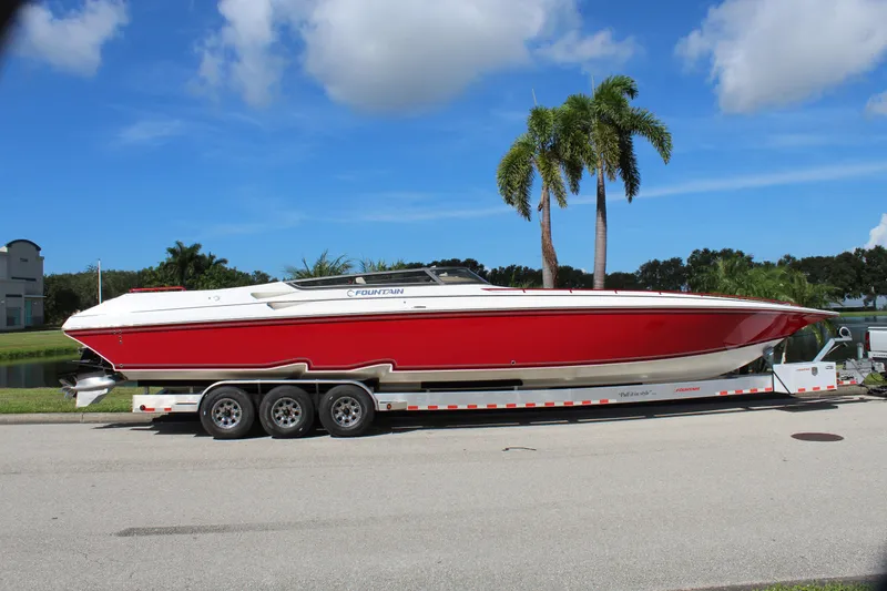Slide: The Image of 2007 Fountain 42 Lightning speedboat on trailer, red and white, parked near palm trees. - 7