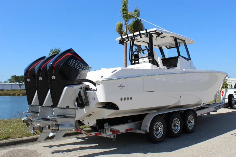 Slide: The Image of 2024 Fountain 32 NX boat on trailer with triple outboard engines. - 20