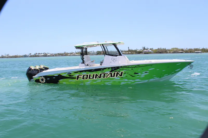 Slide: The Image of 2024 Fountain 32 NX boat on water, vibrant green design, clear sky background. - 3