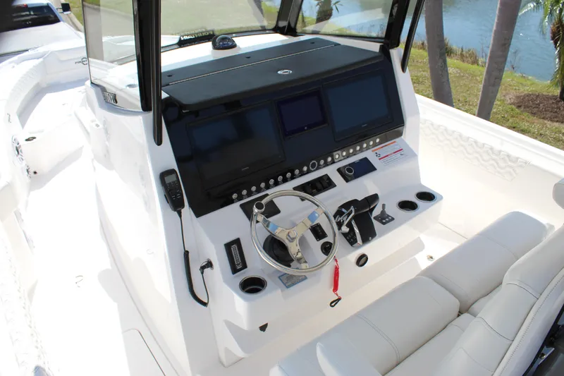 Slide: The Image of 2024 Fountain 32 NX boat cockpit with modern controls and steering wheel. - 53