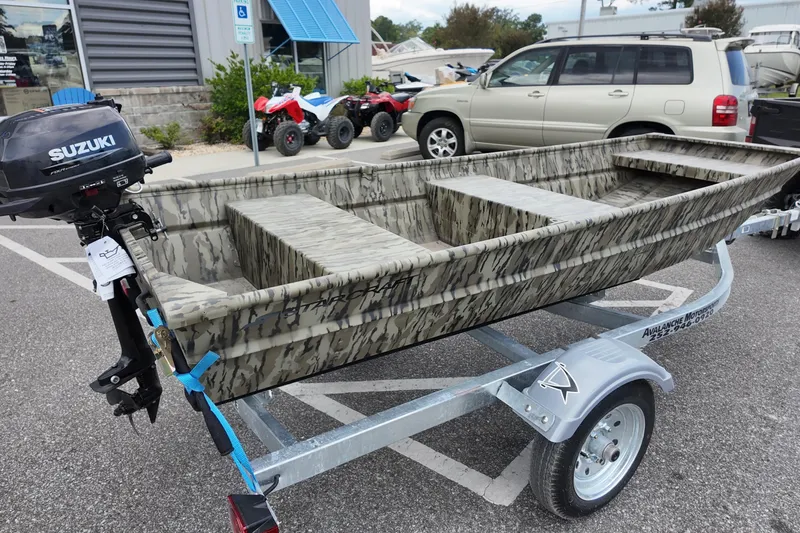 Slide: The Image of 2026 Starcraft JON 1032 boat on trailer with Suzuki motor, parked outdoors. - 2