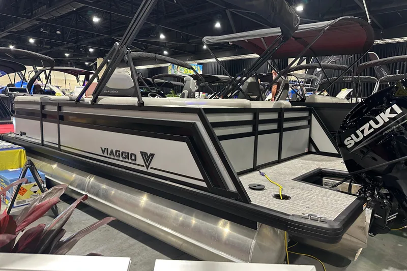Slide: The Image of 2026 Viaggio Lago X20U pontoon boat displayed indoors with Suzuki engine. - 3