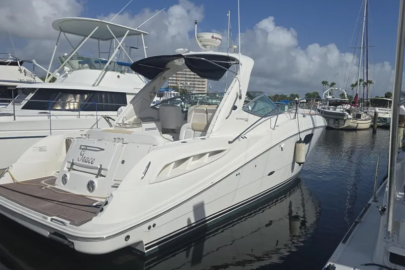 The Image of 2010 Sea Ray 350 Sundancer yacht docked in a marina under a clear blue sky. - 0