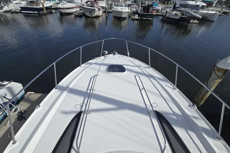 Slide: The Image of 2010 Sea Ray 350 Sundancer yacht docked at marina, surrounded by other boats. - 11