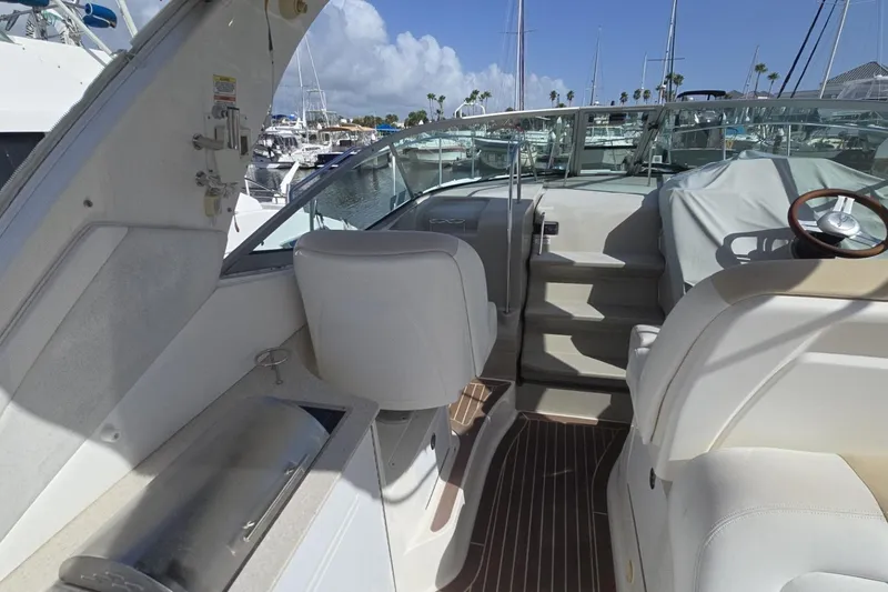 Slide: The Image of 2010 Sea Ray 350 Sundancer boat interior with helm, seating, and marina view. - 17