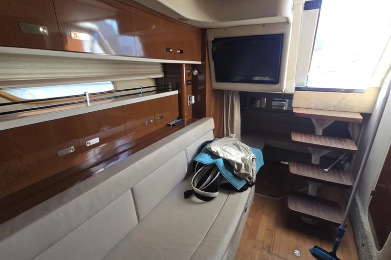 Slide: The Image of Interior of 2010 Sea Ray 350 Sundancer yacht with sofa, TV, and wooden stairs. - 3