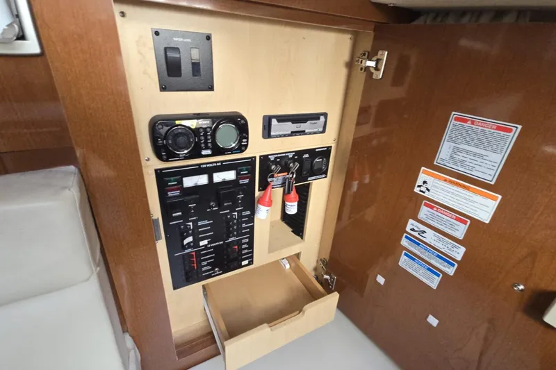 Slide: The Image of Control panel inside 2010 Sea Ray 350 Sundancer boat, featuring switches and safety labels. - 4