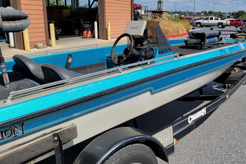 Slide: The Image of 1995 Champion 181 SC boat with blue accents on a trailer in a parking lot. - 2