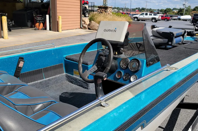 Slide: The Image of 1995 Champion 181 SC boat interior with Garmin GPS, blue seats, and dashboard controls. - 5