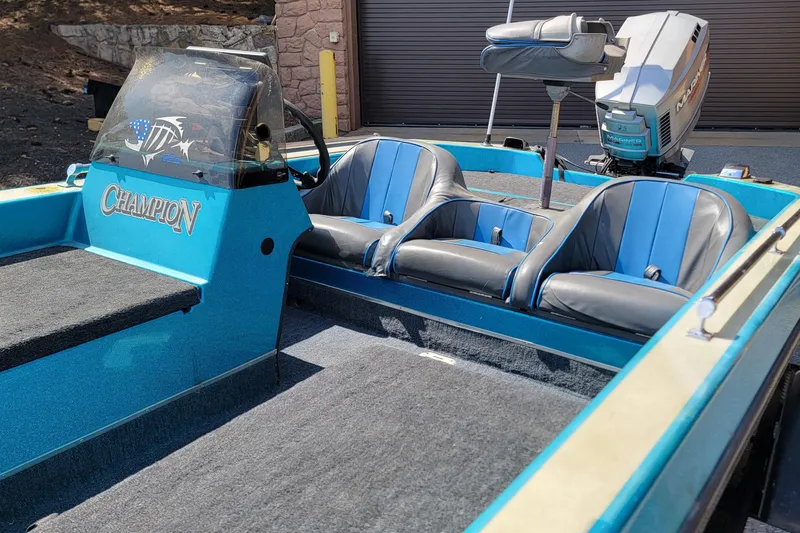 Slide: The Image of 1995 Champion 181 SC boat interior with blue and black seats, Mariner outboard motor. - 8