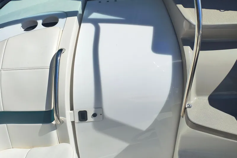 Slide: The Image of 2003 Formula 260 Sun Sport boat interior with seating and cup holder, docked on water. - 22