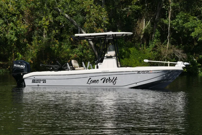 The Image of 2022 Carolina Skiff 23 Ultra Elite boat named "Lone Wolf" on a calm river. - 0
