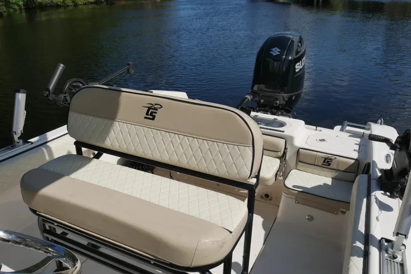 Slide: The Image of 2022 Carolina Skiff 23 Ultra Elite boat interior with seating and Suzuki outboard motor. - 10