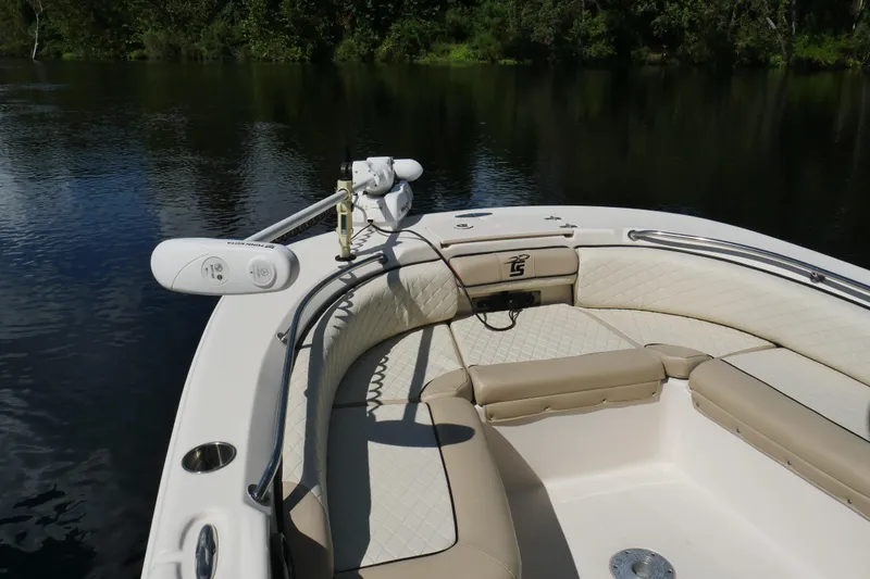 Slide: The Image of 2022 Carolina Skiff 23 Ultra Elite boat interior with cushioned seating on calm water. - 11