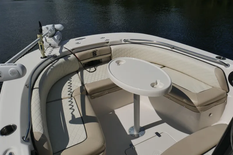 Slide: The Image of 2022 Carolina Skiff 23 Ultra Elite boat interior with cushioned seating and table. - 13