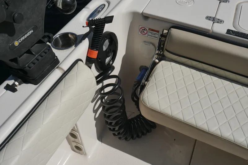Slide: The Image of 2022 Carolina Skiff 23 Ultra Elite boat interior with coiled hose and cushioned seating. - 19