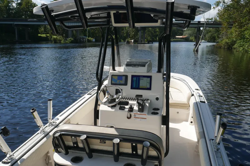 Slide: The Image of 2022 Carolina Skiff 23 Ultra Elite boat on a serene river with bridge in background. - 7