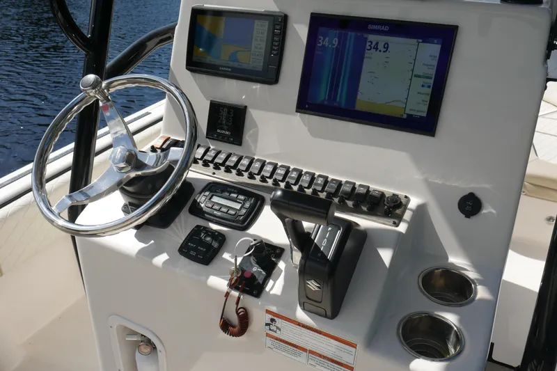 Slide: The Image of 2022 Carolina Skiff 23 Ultra Elite dashboard with steering wheel and navigation screens. - 8