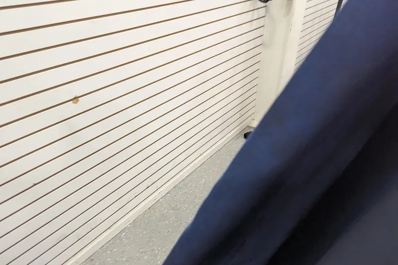 Slide: The Image of White slatwall panel with blue fabric in foreground, indoors. - 10