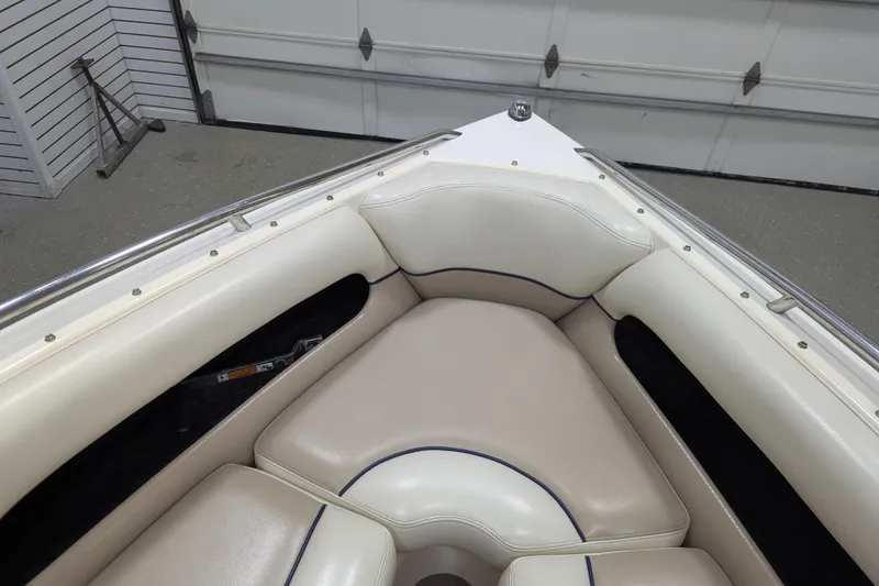 Slide: The Image of 1998 Malibu Sunsetter VLX boat interior with white cushioned seating in a garage setting. - 12