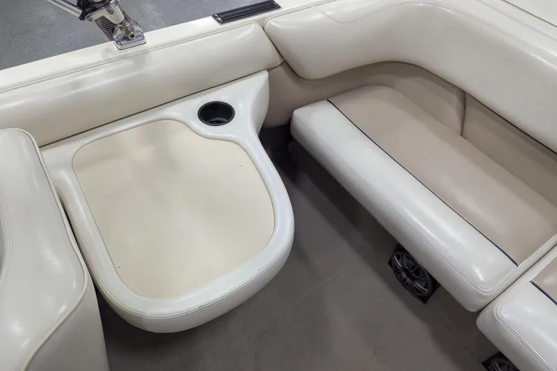 Slide: The Image of 1998 Malibu Sunsetter VLX boat interior with white leather seating and cup holder. - 23