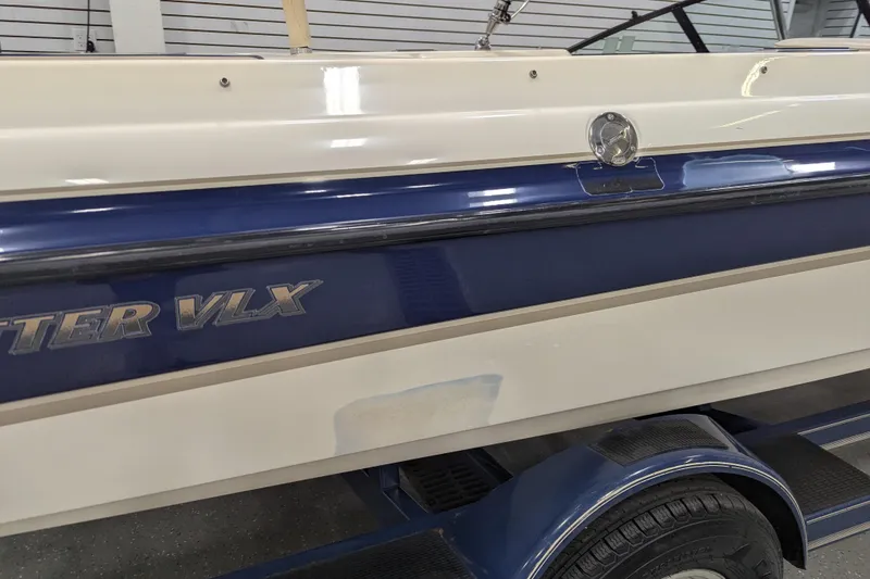 Slide: The Image of 1998 Malibu Sunsetter VLX boat side view with blue and white detailing. - 3
