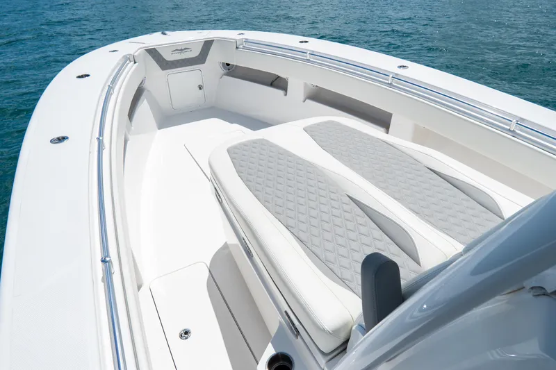 Slide: The Image of 2023 Invincible 36 Open Fisherman boat interior with cushioned seating on calm water. - 5