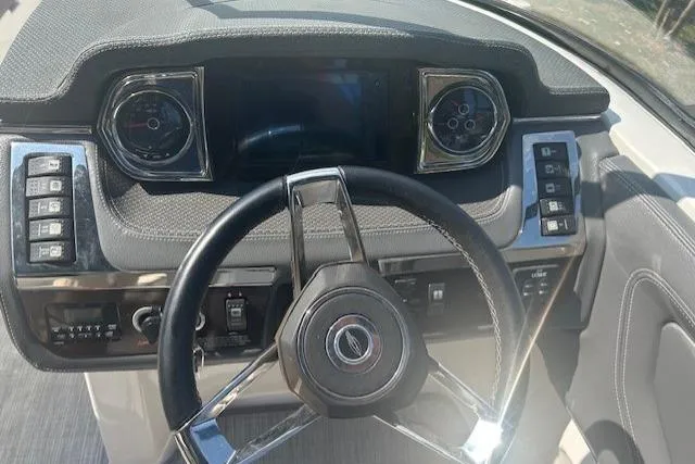 Slide: The Image of Steering wheel and dashboard of 2017 Chaparral 277 SSX boat, featuring modern controls. - 5