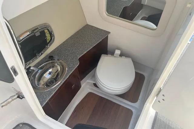Slide: The Image of 2017 Chaparral 277 SSX boat bathroom with sink, toilet, and wood accents. - 6