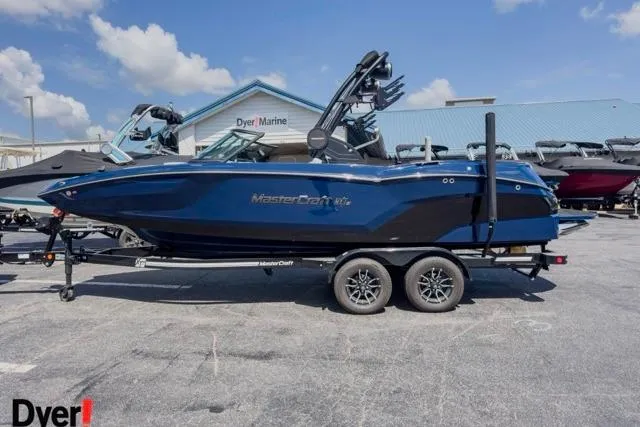The Image of 2026 MasterCraft NXT22 boat in blue, parked at Dyer Marine dealership. - 0