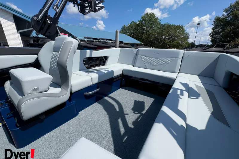 Slide: The Image of 2026 MasterCraft NXT22 boat interior with modern seating and sleek design under a blue sky. - 10