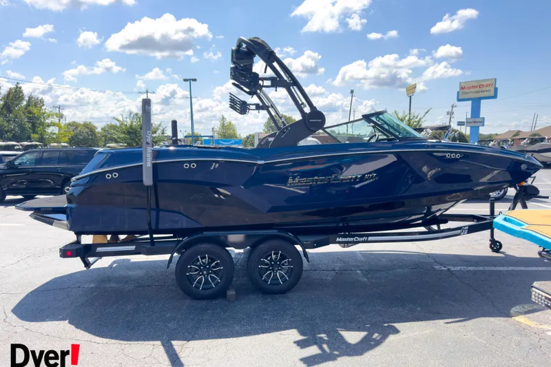 Slide: The Image of 2026 MasterCraft NXT22 boat on trailer in sunny parking lot. - 4
