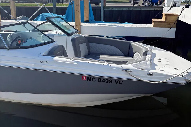 The Image of 2026 NauticStar 223 DC Deck boat docked, featuring sleek design and comfortable seating. - 0