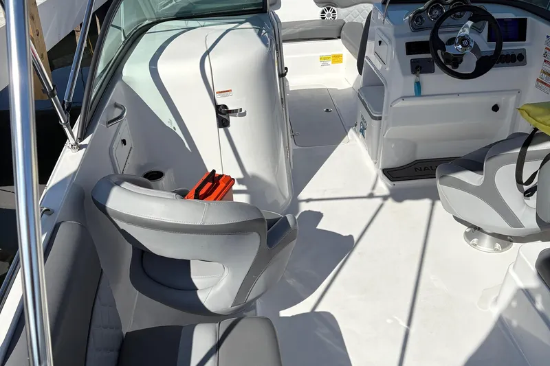 Slide: The Image of 2026 NauticStar 223 DC Deck boat interior with modern seating and steering console. - 5