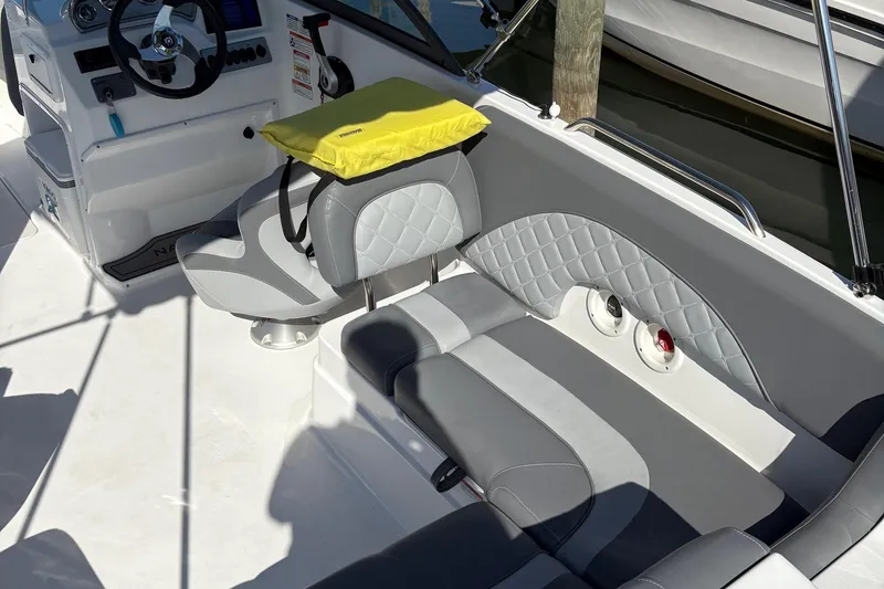 Slide: The Image of 2026 NauticStar 223 DC Deck boat interior with gray seating and steering wheel. - 6