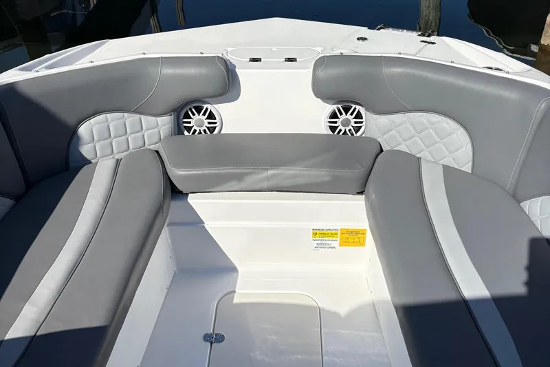 Slide: The Image of 2026 NauticStar 223 DC Deck boat interior with gray seating and speakers. - 9