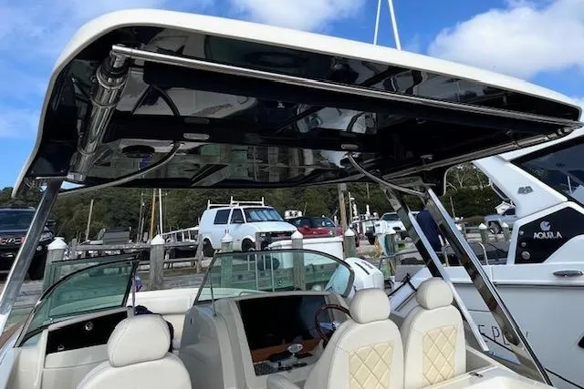 Slide: The Image of 2022 Chris-Craft Calypso 30 boat interior with seating and canopy at a marina. - 11