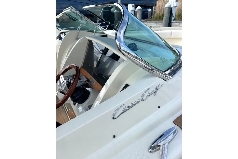 Slide: The Image of 2022 Chris-Craft Calypso 30 boat interior with steering wheel and windshield detail. - 14