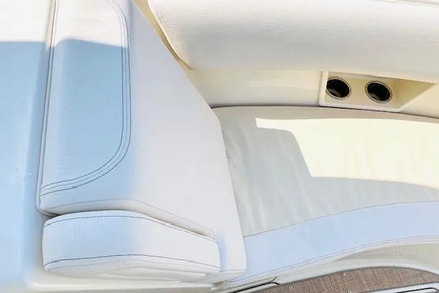 Slide: The Image of 2022 Chris-Craft Calypso 30 boat interior with white cushioned seating and cup holders. - 22