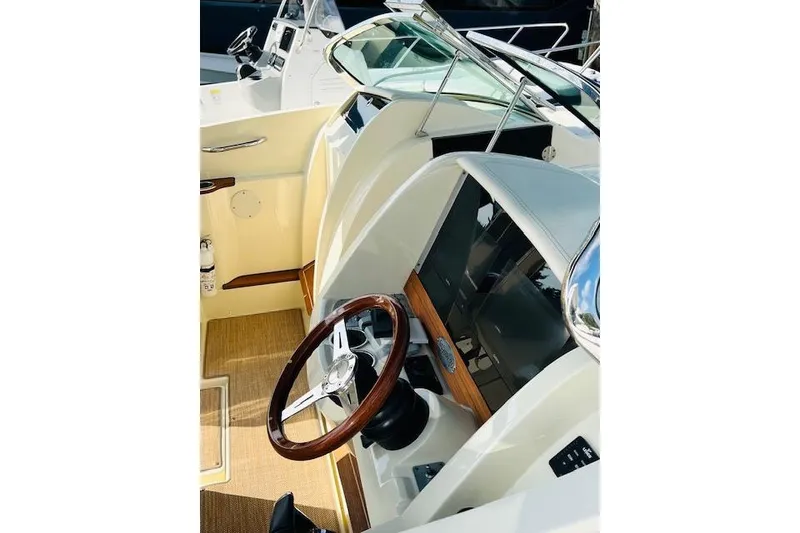 Slide: The Image of 2022 Chris-Craft Calypso 30 boat interior with wooden steering wheel and modern dashboard. - 29